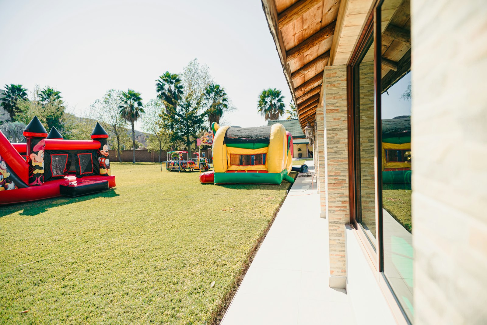 Two inflatable bounce houses set up on a large lawn.