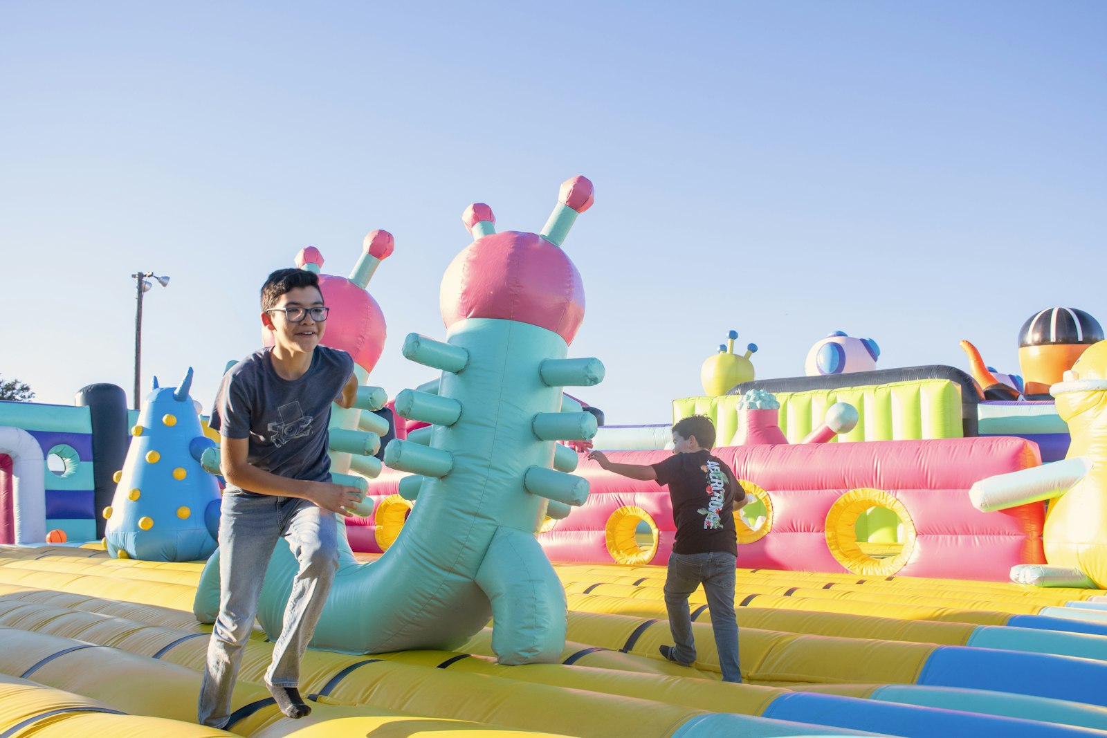 Children playing on a large inflatable obstacle course.